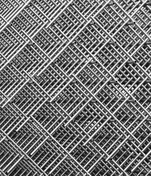 Abstract close-up of interwoven metal grids creating a symmetrical, textured pattern in monochrome.